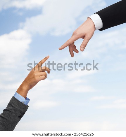 business, people, cooperation and connection concept - close up of woman and man hands trying to connect over blue sky background