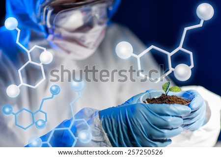science, biology, ecology, research and people concept - close up of young scientist holding petri dish with plant and soil sample in bio laboratory over molecular structure