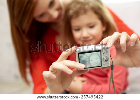 people, family and technology concept - close up of happy mother and little daughter with camera taking selfie
