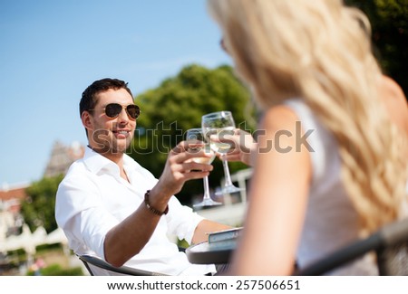 summer holidays and dating concept - man drinking wine with woman in cafe in the city