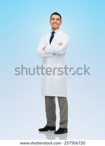 healthcare, profession, people and medicine concept - smiling male doctor in white coat over blue background