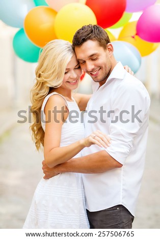 summer holidays, celebration and wedding concept - couple with colorful balloons and engagement ring