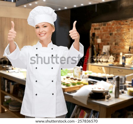 cooking, bakery, gesture and food concept - smiling female chef, cook or baker showing thumbs up over restaurant kitchen background