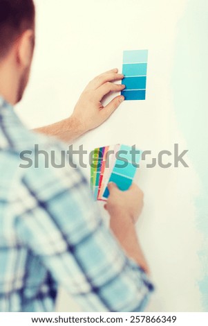 repair, building, technology and home concept - close up of male with color pallets choosing color