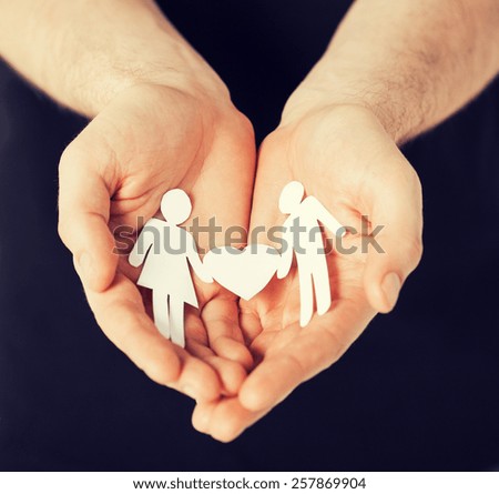 man hands showing two paper men with heart shape