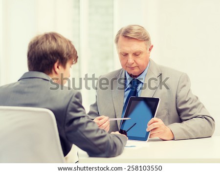 business, advertisement, technology and office concept - older man and young man with tablet pc computer in office