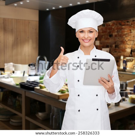 cooking, bakery, people, technology and food concept - smiling female chef cook or baker with tablet pc computer showing thumbs up over restaurant kitchen background