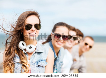 summer holidays and teenage concept - teenage girl with friends outside