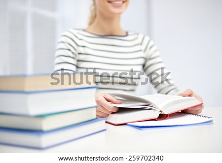 business, high school, education, people and learning concept - close up of young woman reading book at school