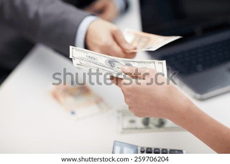 finances, currency, exchange rate, business and people concept - close up of male and female hands giving or exchanging money at office