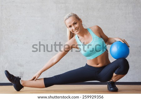 fitness, sport, training and people concept - smiling woman with exercise ball in gym