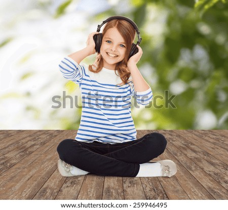 music, childhood, people and technology concept - happy girl with headphones listening to music over greed background