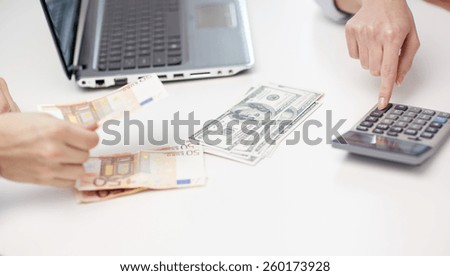 finances, currency, exchange rate,  technology and people concept - close up of hands counting dollar and euro money with calculator