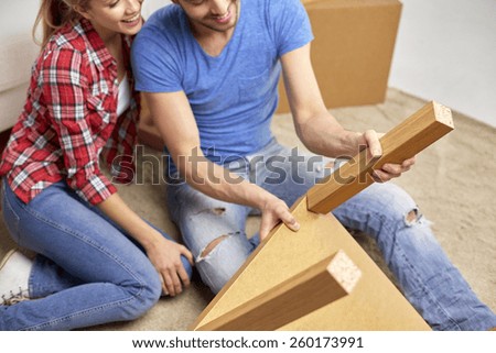 repair, renovation and people concept - close up of couple unpacking furniture and moving to new home