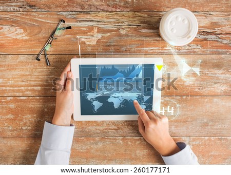 business, people, economics, statistics and technology concept - close up of hands pointing finger to tablet pc computer screen with virtual graph projection coffee cup and eyeglasses on table