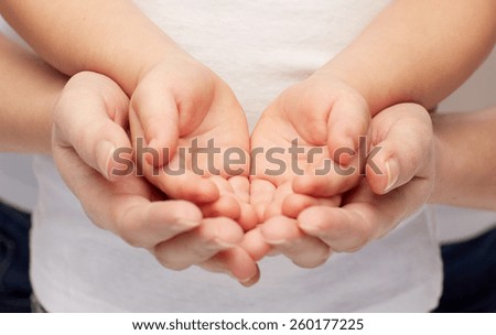 people, charity, family and advertisement concept - close up of woman and girl holding something in empty cupped hands