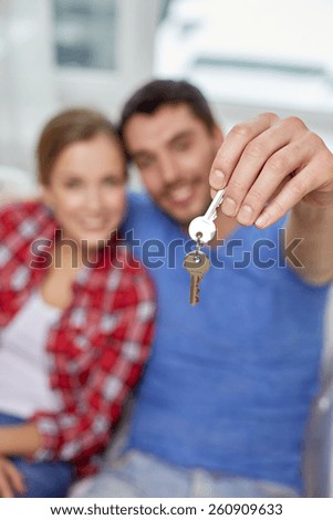 people, real estate, home and family concept - close up of happy couple showing key at at home