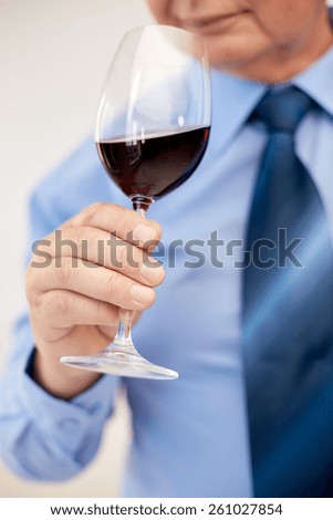 profession, drinks, holidays and people concept - close up of senior man drinking red wine from glass