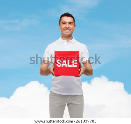 shopping, consumerism, discount and people concept - smiling man with red sale sigh over blue sky and cloud background