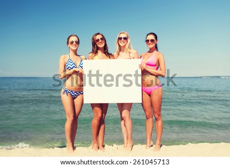 summer vacation, holidays, travel, advertising and people concept - group of smiling young women with big white blank billboard on beach