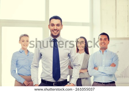 business and office concept - smiling handsome businessman with team in office