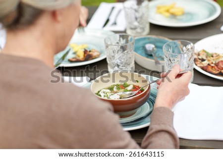 family, home, dinner, holidays and people concept - close up of woman eating soup in summer garden