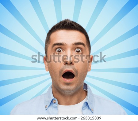fear, emotions, horror and people concept - face of scared man shouting blue burst rays background