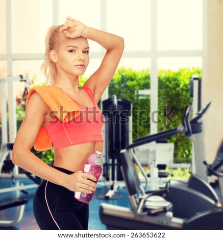 sport, exercise and healthcare concept - tired sporty woman with orange towel and water bottle