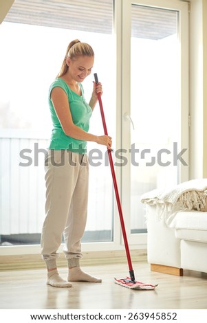 people, housework and housekeeping concept - happy woman with mop cleaning floor at home