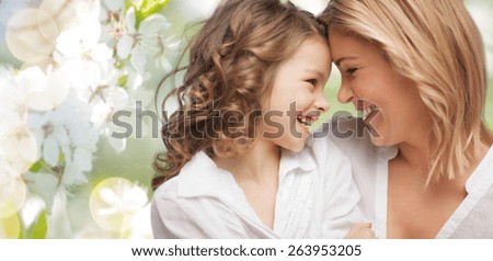 people, family, love and harmony concept - happy mother and daughter cuddling over green summer garden background