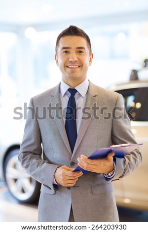 auto business, car sale, consumerism and people concept - happy man with clipboard at auto show or salon