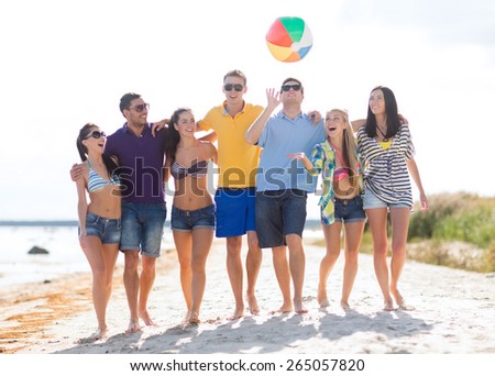 summer holidays, vacation, tourism, travel and people concept - group of happy friends playing with inflatable ball walking along beach
