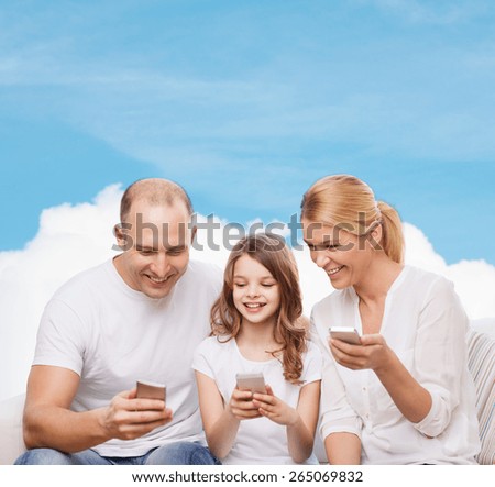 family, technology and people - smiling mother, father and little girl with smartphones over blue sky and white cloud background