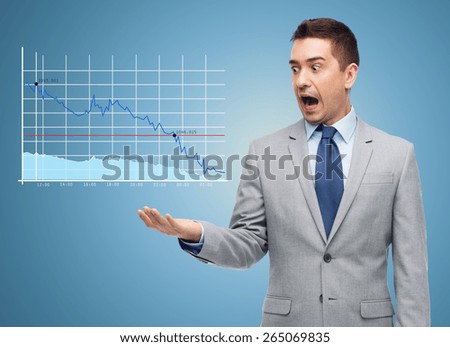 business, people, emotions and failure concept - shocked businessman in suit looking to chart over blue background