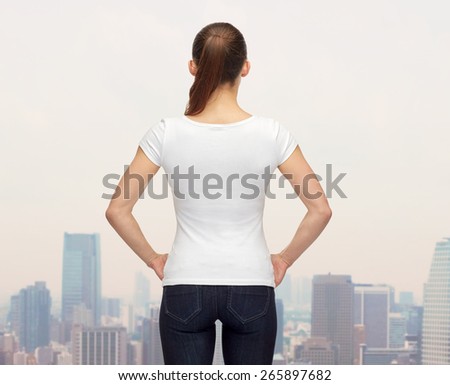 t-shirt design, advertisement and people concept - woman in blank white t-shirt from back over city background