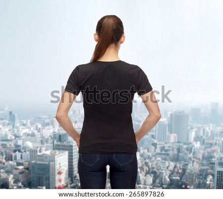 t-shirt design, advertisement and people concept - woman in blank black t-shirt from back over city background