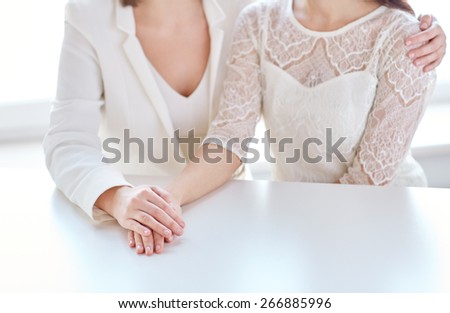 people, homosexuality, same-sex marriage and love concept - close up of happy married lesbian couple hugging