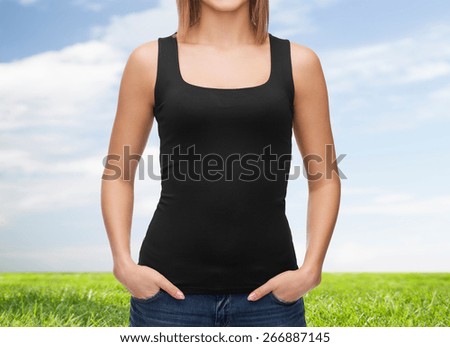 clothing design, fashion, advertisement and people concept - close up of woman in blank black tank top over blue sky and grass background