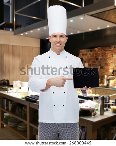 cooking, profession and people concept - happy male chef cook showing tablet pc computer black blank screen over restaurant kitchen