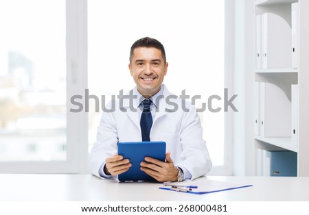 healthcare, profession, people and medicine concept - smiling male doctor in white coat with tablet pc in medical office
