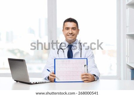 medicine, profession, technology and people concept - happy male doctor with clipboard and laptop computer in medical office