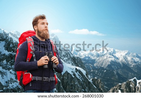 adventure, travel, tourism, hike and people concept - man with red backpack and binocular over alpine mountains background