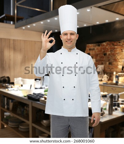 cooking, profession, gesture and people concept - happy male chef cook showing ok sign over restaurant kitchen