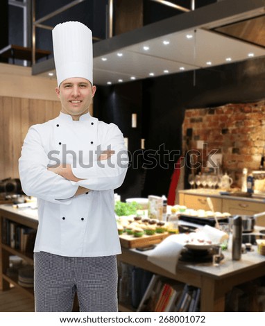 cooking, profession and people concept - happy male chef cook with crossed hands over restaurant kitchen