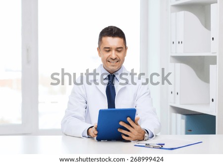 healthcare, profession, people and medicine concept - smiling male doctor in white coat with tablet pc in medical office