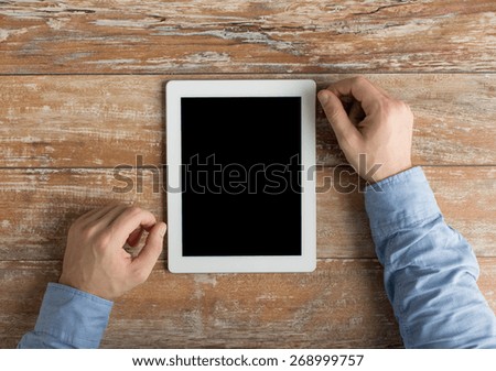 business, education, people and technology concept - close up of male hands with tablet pc computer on table