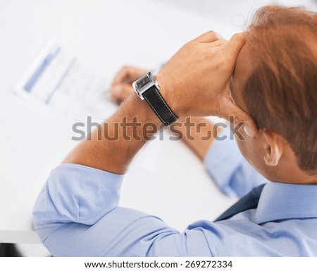 business, office, school and education concept - stressed man filling tax form