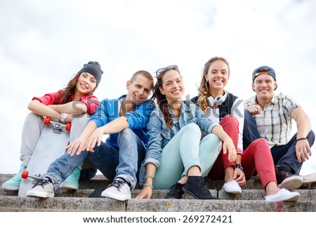 summer holidays and teenage concept - group of smiling teenagers hanging outside