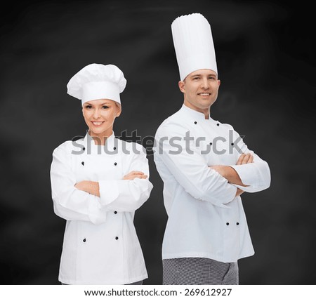 cooking, profession and people concept - happy male chef cook with crossed hands over black chalk board background