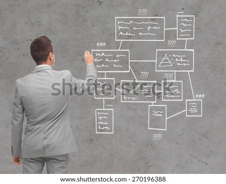 business, people, advertisement , information and office concept - businessman writing or drawing scheme over concrete wall background from back